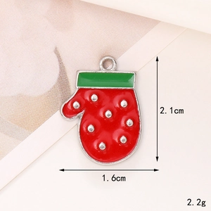 Macro detail of red Christmas glove charm with green trim and silver dots, size 2.1x1.6cm