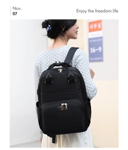 Close-up of black waterproof nylon mommy backpack with gold zippers and large side pockets