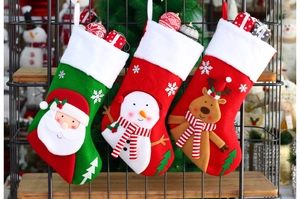 Close-up of three knitted Christmas stockings featuring Santa, Snowman and Reindeer patterns