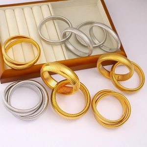 Detail of gold and silver stainless steel flexible spring bracelets with spiral texture