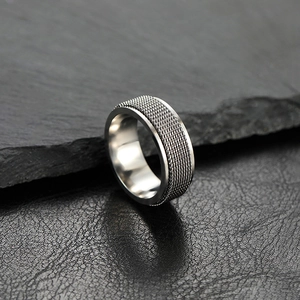 8mm silver spinner ring in stainless steel with industrial mesh texture on rock background