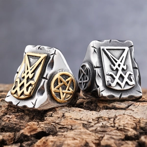 Close-up of stainless steel Sigil of Lucifer ring and pentagram on a wood surface