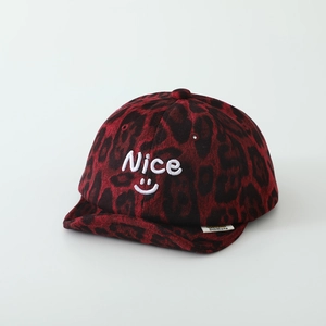 Detail of baby soft brim cap featuring red leopard print and Nice embroidery