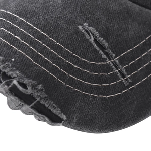 Macro shot of vintage black cotton baseball cap showing distressed brim and stitch detail