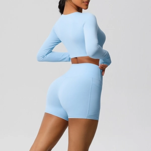 Detail van lichtblauwe yogaset met crop top met lange mouwen en high-waist shorts met zijzakken