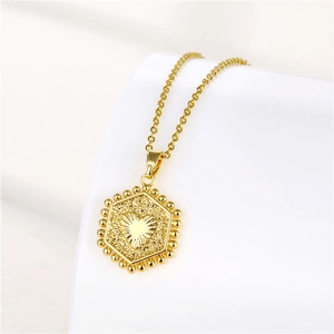 Detailed close-up of a gold hexagonal pendant with a heart relief and beaded edge