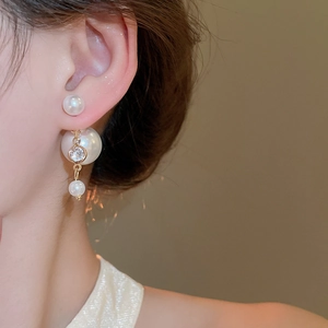 Macro detail of double-sided pearl earrings with gold plating and cubic zirconia accents