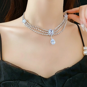 Macro shot of silver-colored layered necklace with sparkling teardrop and oval rhinestones