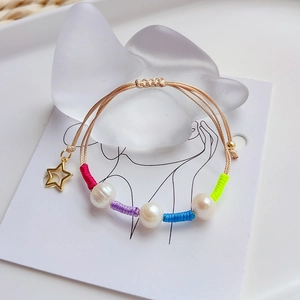 Handmade pearl bead bracelet with hollow star charm and colorful woven thread accents