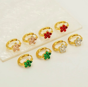 Détail macro de créoles plaquées or 18K avec pétales de fleurs en zircons colorés
