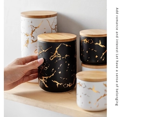 Detail of Nordic marble pattern ceramic jars with airtight bamboo lids on wooden shelf