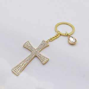 Close-up of golden rhinestone cross keychain with water drop diamond pendant detail