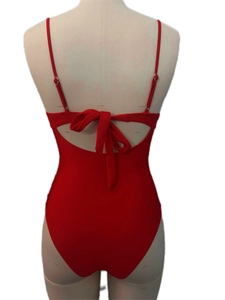 Detail of red one-piece swimsuit featuring a cut-out back and adjustable bow tie ribbons