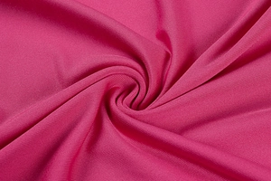 Detailed view of magenta fabric with a silky sheen and soft drape texture