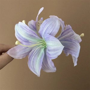 Detailed macro view of a 3D lily hair claw with purple and green gradient fabric petals
