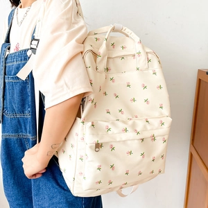 Detail of floral backpack showing delicate pink flower patterns and canvas texture