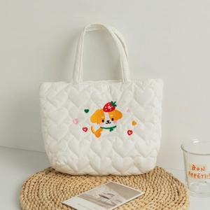 Detail of white quilted lunch bag featuring heart stitching and cute puppy embroidery