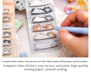 Close-up of cute cat shaped index stickers on writing paper for creative note-taking