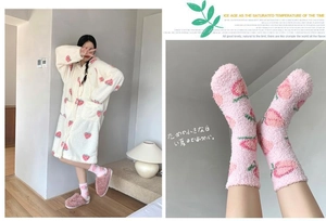 Detail of coral fleece strawberry plush robe and pink peach socks for winter comfort