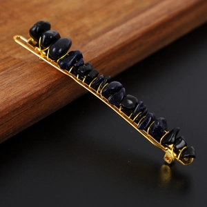Close-up of golden hair clip with blue natural stone chips and wire-wrapped detail