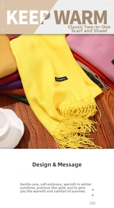Detailed close-up of folded cashmere scarves with tassels in vibrant colors on a wood table