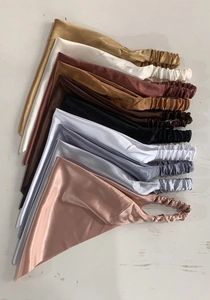 Detailed top view of various satin triangular headbands in multiple glossy solid colors