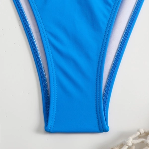 Detailed close-up of blue bikini bottom showing high-quality stitching and white mesh lining