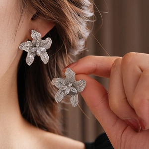 Nahaufnahme glitzernder Ohrstecker in Blumenform mit feinen Zirkonia-Steinen besetzt