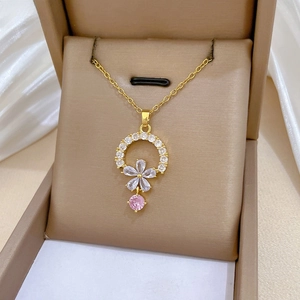 Macro view of gold pendant with floral zircon halo and white drop-shaped gems