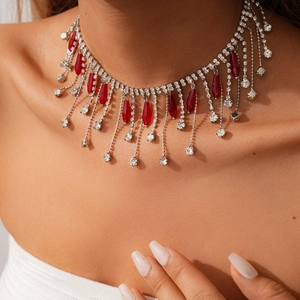 Détail d'un collier à pampilles géométriques avec pierres rubis et diamants blancs