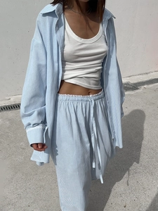 Detail of blue striped trousers featuring a white lace waistband and adjustable drawstring