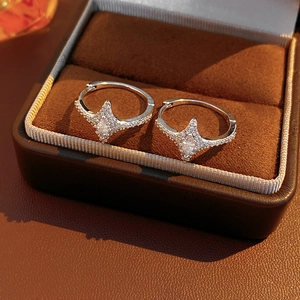 Macro shot of silver star earrings with pavé zircon and marquise center stone in a box