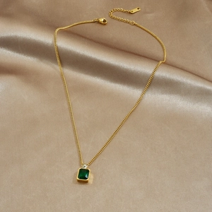 Gold stainless steel necklace with green square gemstone and zircons on champagne satin