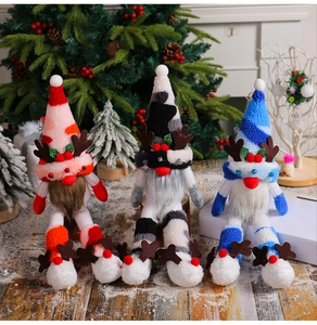 Detailed view of three plush Christmas reindeer gnomes in red, blue, and black patterns
