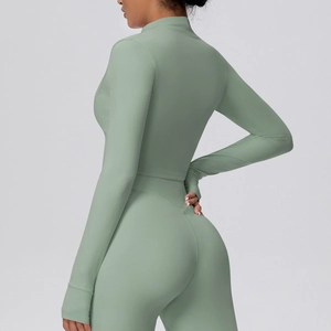 Detail der eng anliegenden Sportjacke und Yogahose in Salbeigrün mit nahtloser Textur