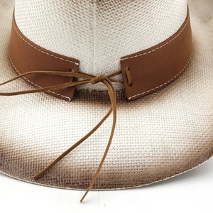 Gros plan sur un chapeau de paille avec bande en cuir et bordure à dégradé rustique