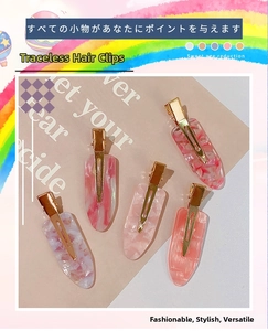 Detail of five marble texture acetate hair clips with golden metal duckbill clips