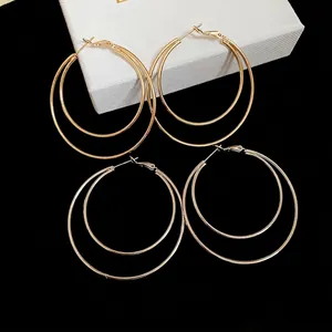Minimalist double layered gold hoop earrings with a polished geometric circular design