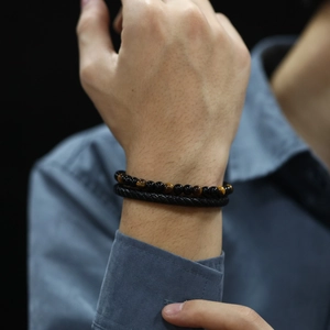 Close-up of double-layer bracelet with black agate beads and woven leather on wrist
