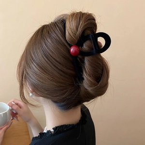 Detail of red bead on black flocked hair claw clip for a vintage hair styling look