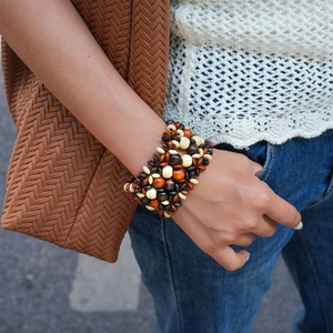 Detail of bohemian multilayered wooden beaded bracelet on wrist with natural earth tones