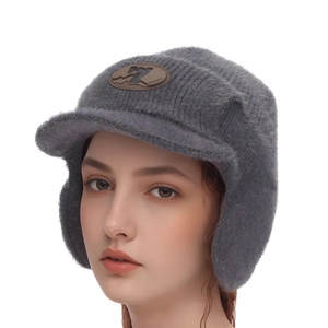 Détail du bonnet en peluche grise avec protège-oreilles et étiquette de marque SWHEL en cuir