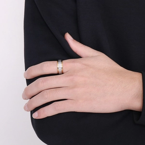 Detail of men's two-tone rotating cross ring in gold and silver finish on finger