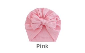 Pink infant turban hat featuring a large soft bow decoration made of knit cotton material