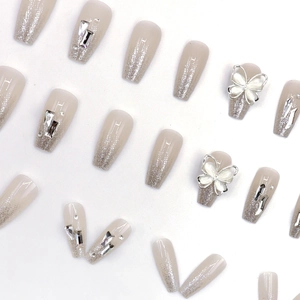 Unghie finte a ballerina nude sfumate con glitter argento e farfalle 3D decorative