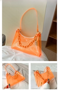 Detail view of orange transparent PVC baguette bag with chunky chain strap