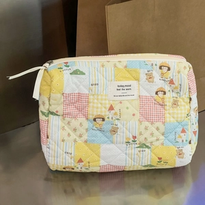 Detailansicht der gesteppten Baumwoll-Kosmetiktasche mit bunten Mustern und Reißverschluss