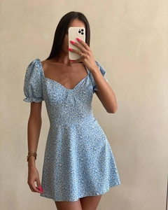 Détail d'une robe courte fleurie bleu clair de style français avec manches bouffantes