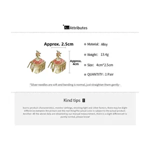Detailed view of gold alloy fan earrings with red enamel scales and 925 silver needles