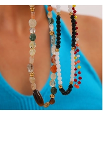 Detail of bohemian gold-plated necklace with colorful natural stone beads and gold spacers